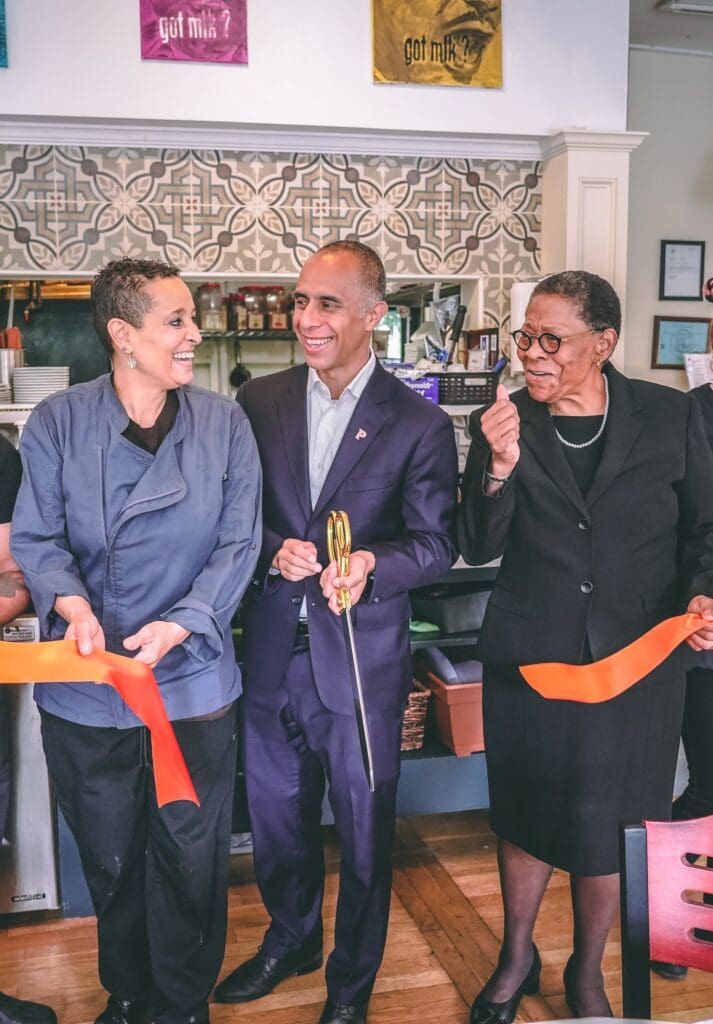 A group of people cutting a ribbon at a restaurant.