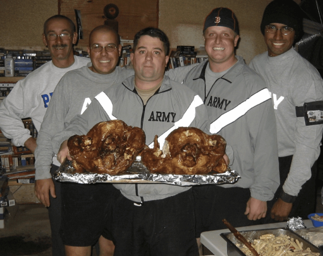 A group of men posing with turkeys.