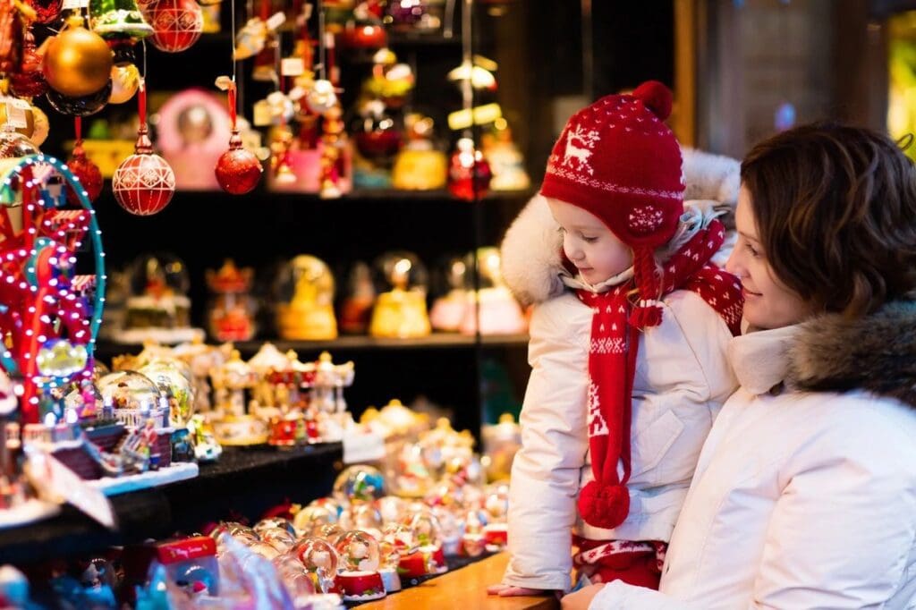 A woman and child looking at christmas ornaments in a store.