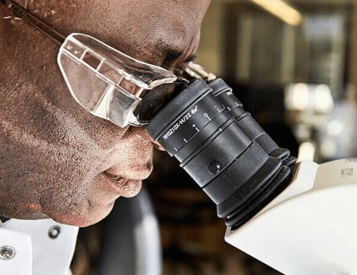 A man looking through a microscope.