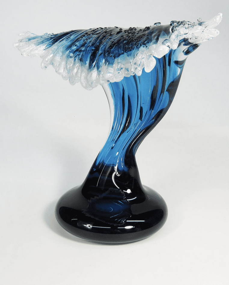 A blue and white glass sculpture on a stand.
