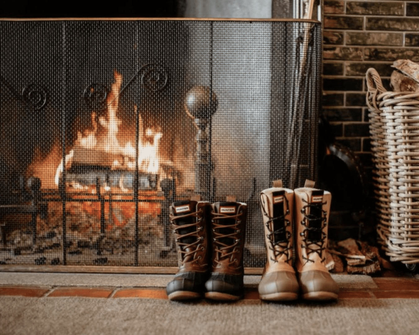 Winter boots in front of a fireplace.