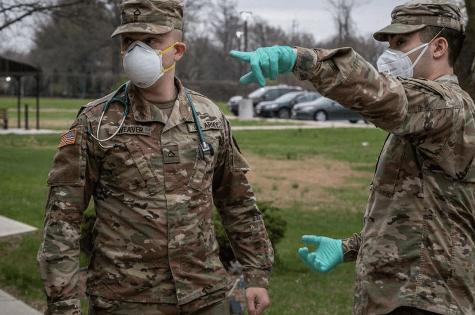 Two military men wearing face masks and gloves.