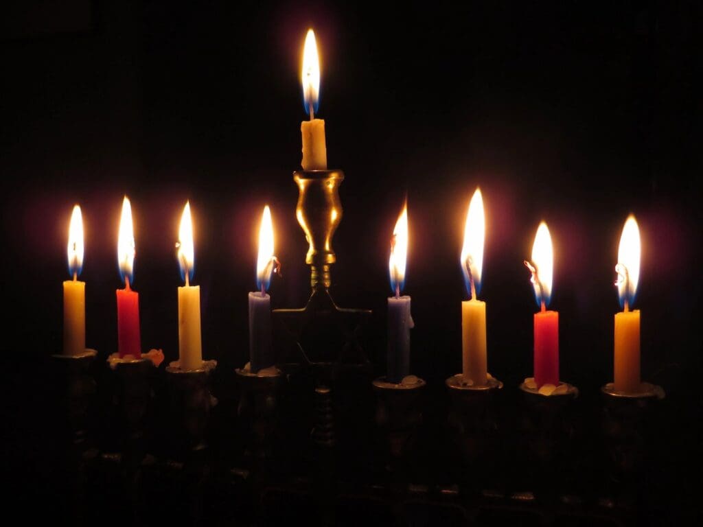 A hanukkah menorah lit up in the dark.