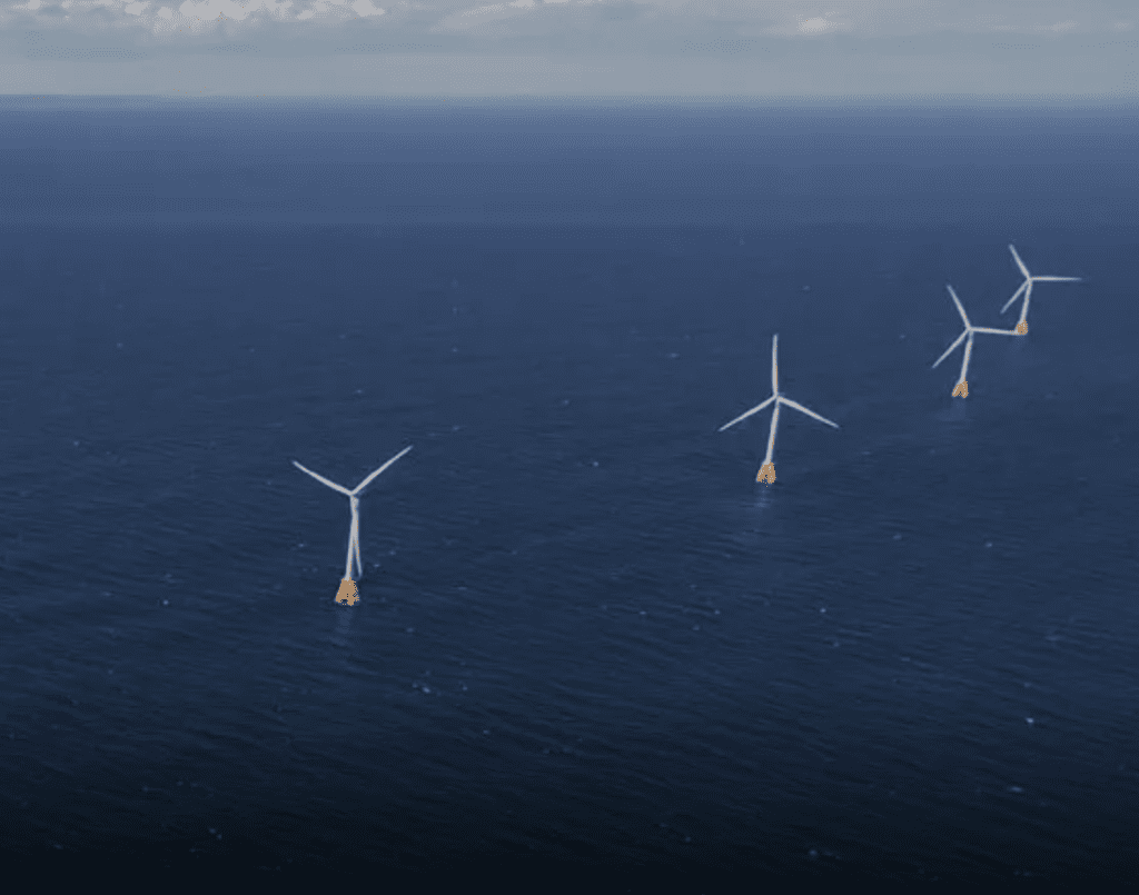 A group of wind turbines in the ocean.