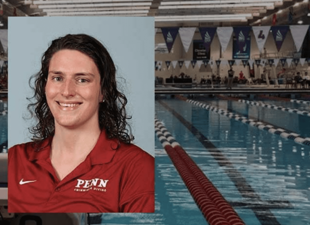 A woman in a red shirt is standing in front of a swimming pool.