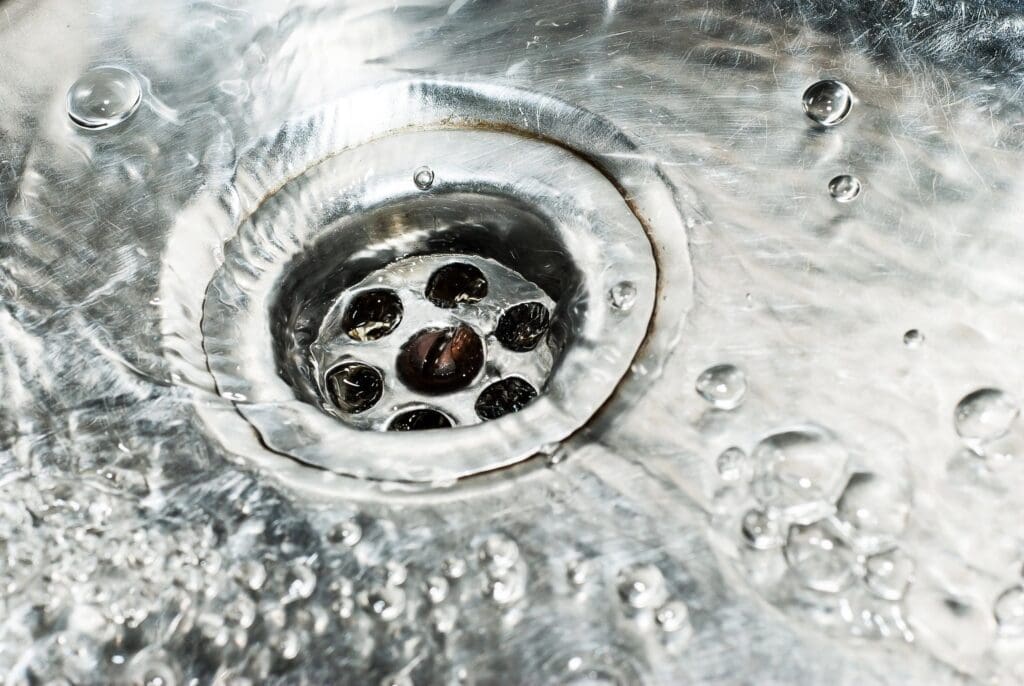 A close up of a sink with water coming out of it.