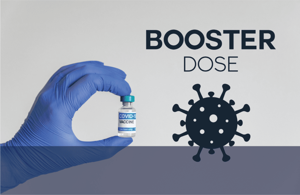 A hand holding a bottle of booster dose with the words coronavirus.