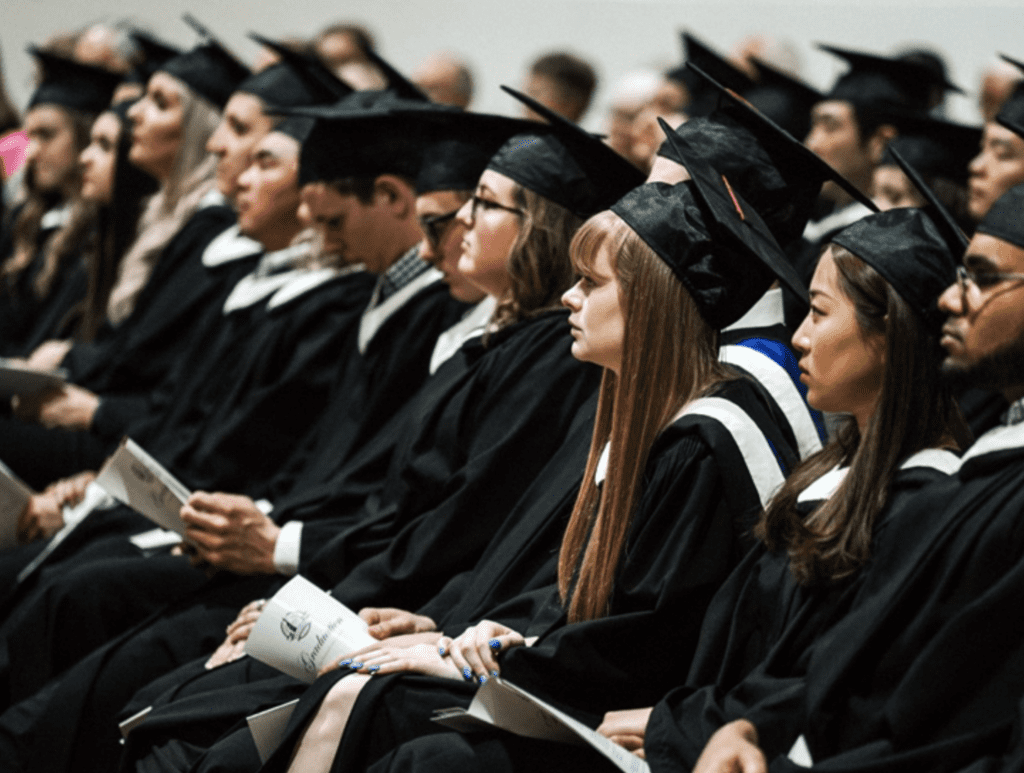A group of graduates sitting in a row.
