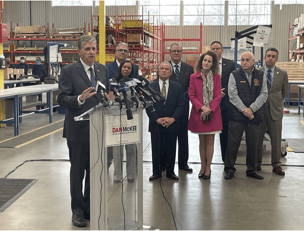 A group of people standing at a podium in a factory.