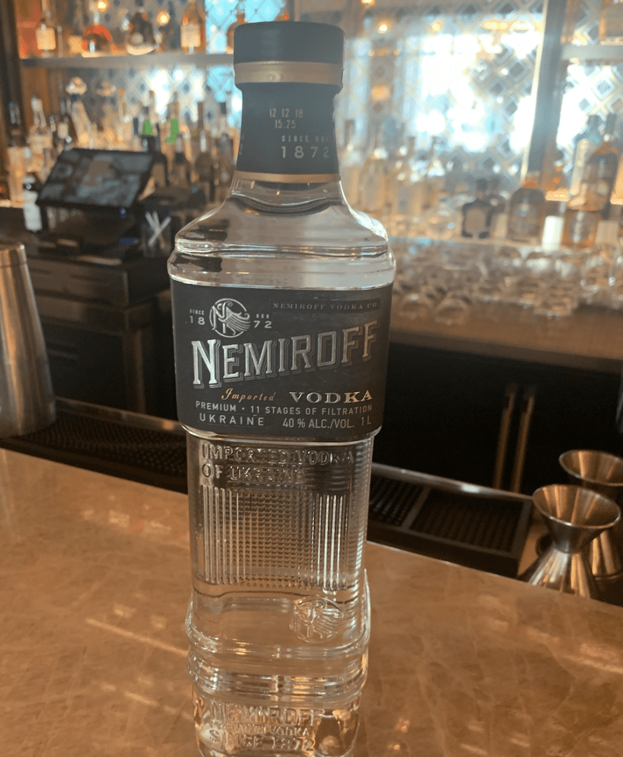 A bottle of nemroff vodka sitting on a bar.