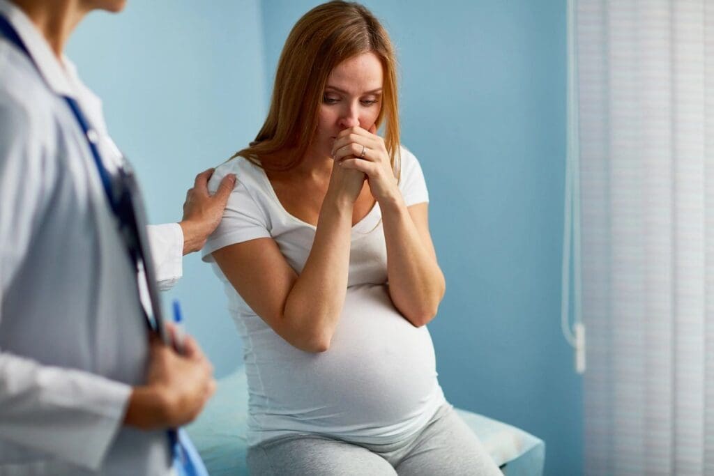 A pregnant woman is being examined by a doctor.