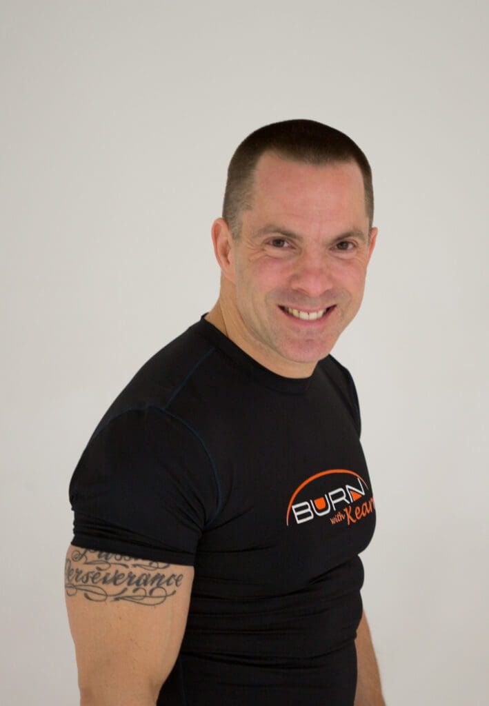 A fit man in a black t-shirt smiling.