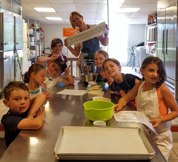 A group of children posing for a picture in a kitchen.