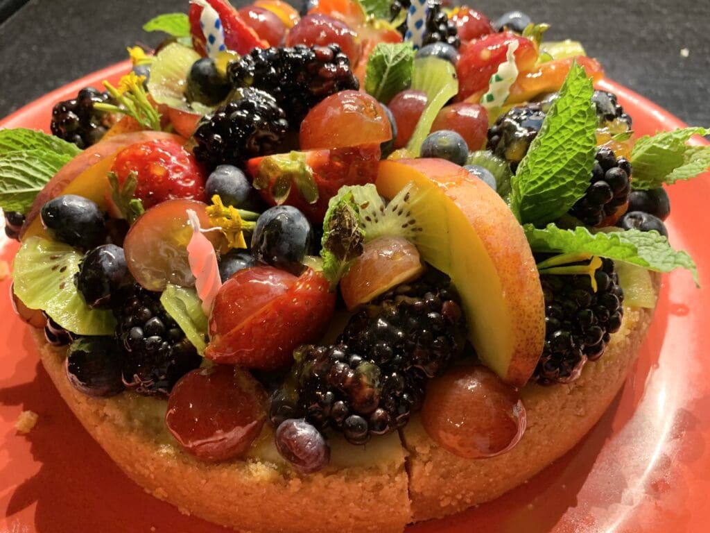 A cake topped with berries and mint.