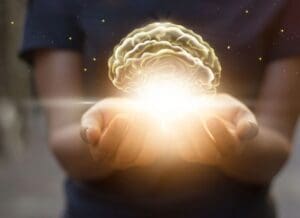 A woman holding a glowing brain in her hands.
