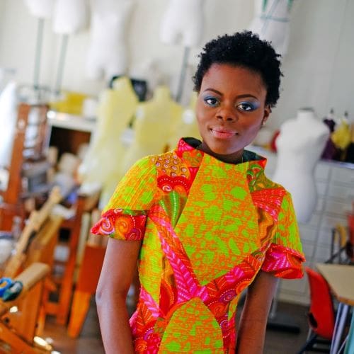 A young african woman in a brightly colored dress.