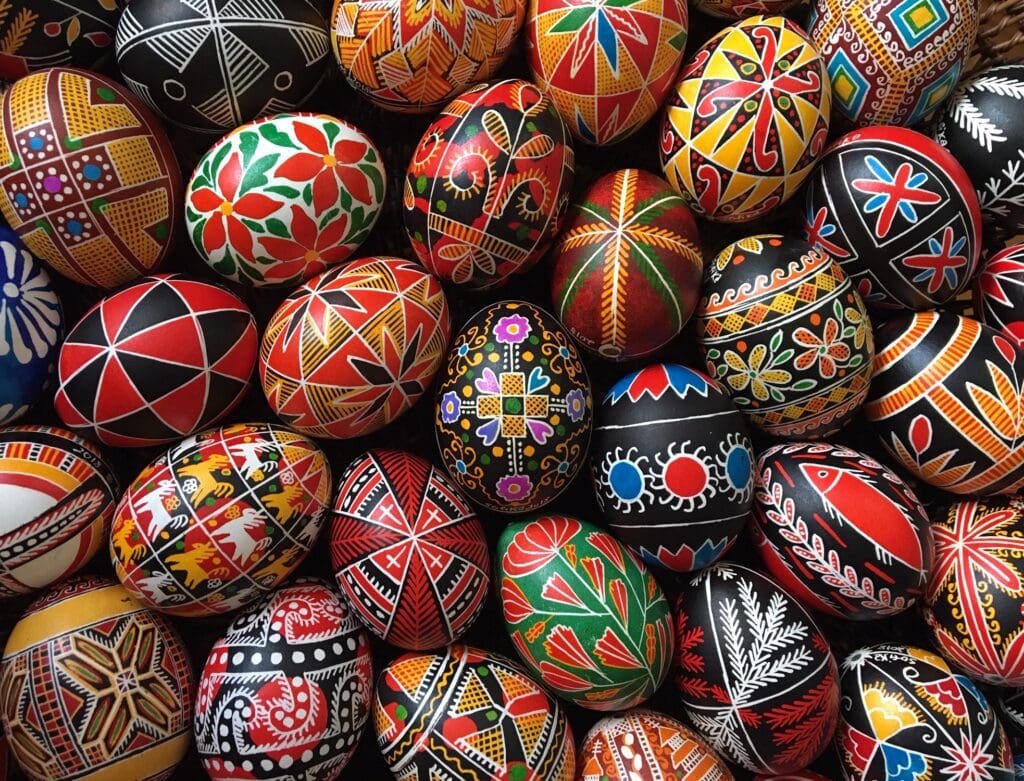 Many colorful painted easter eggs are arranged in a basket.