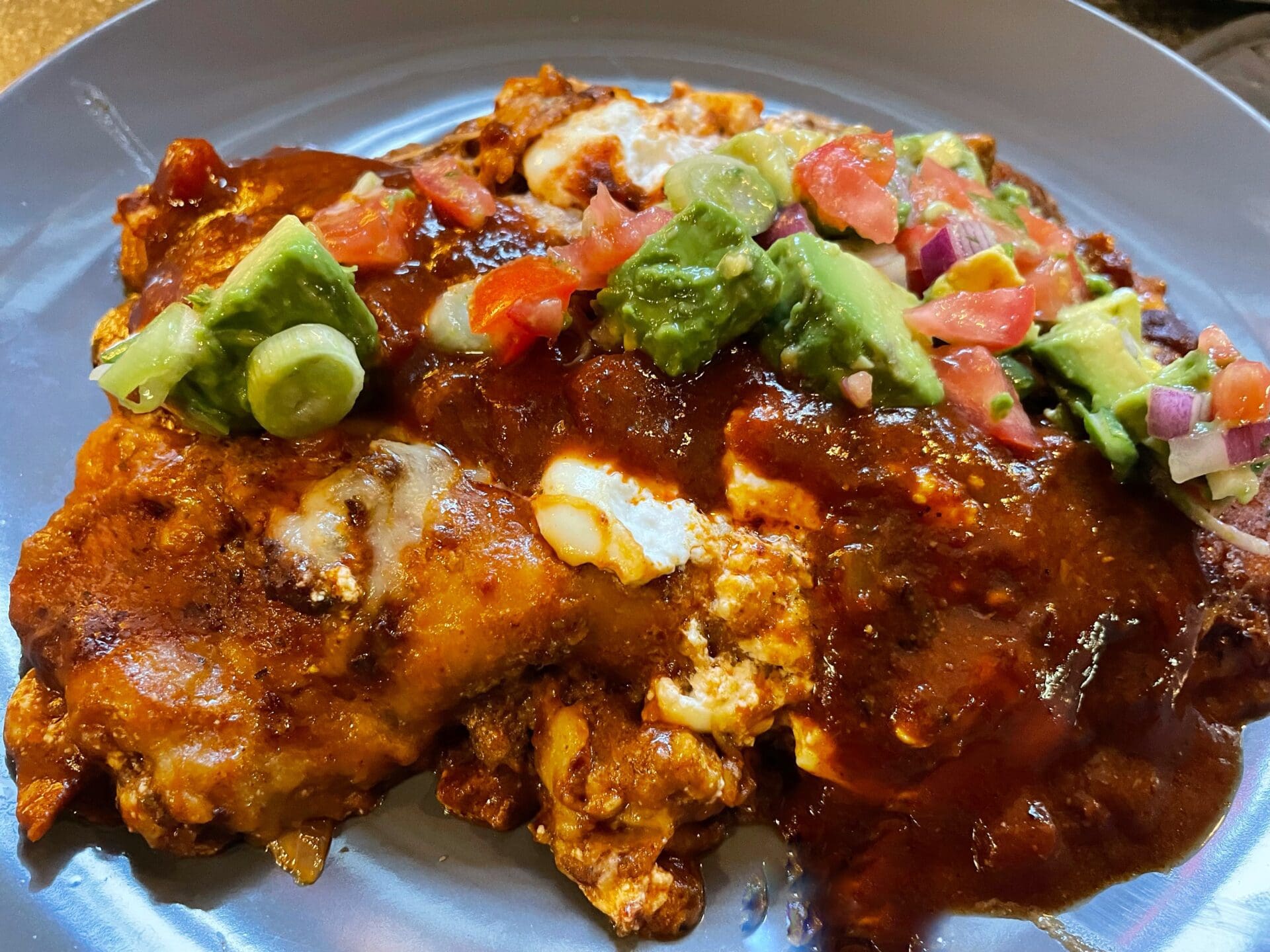 Mexican enchiladas with guacamole on a plate.