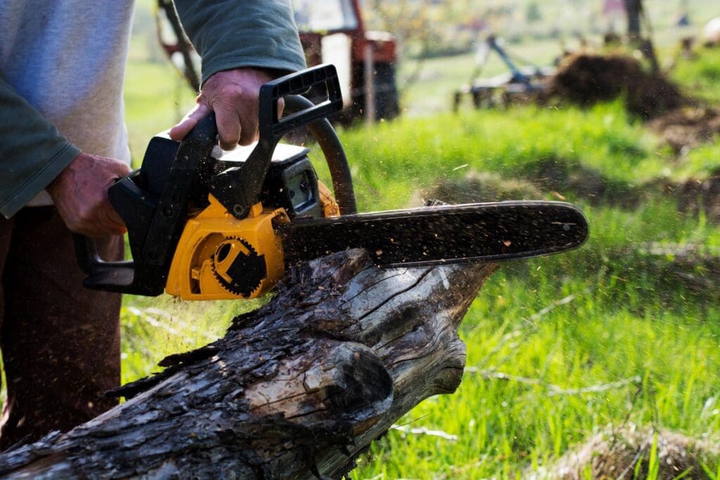 A man cutting a log with a chainsaw.