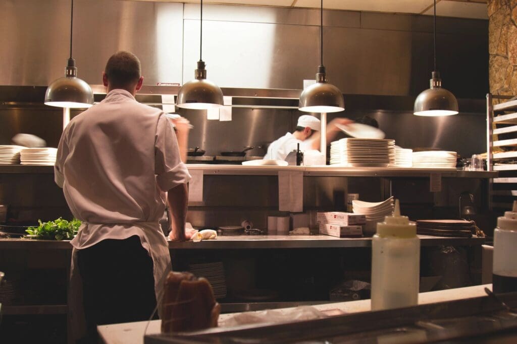 A group of people working in a restaurant kitchen.