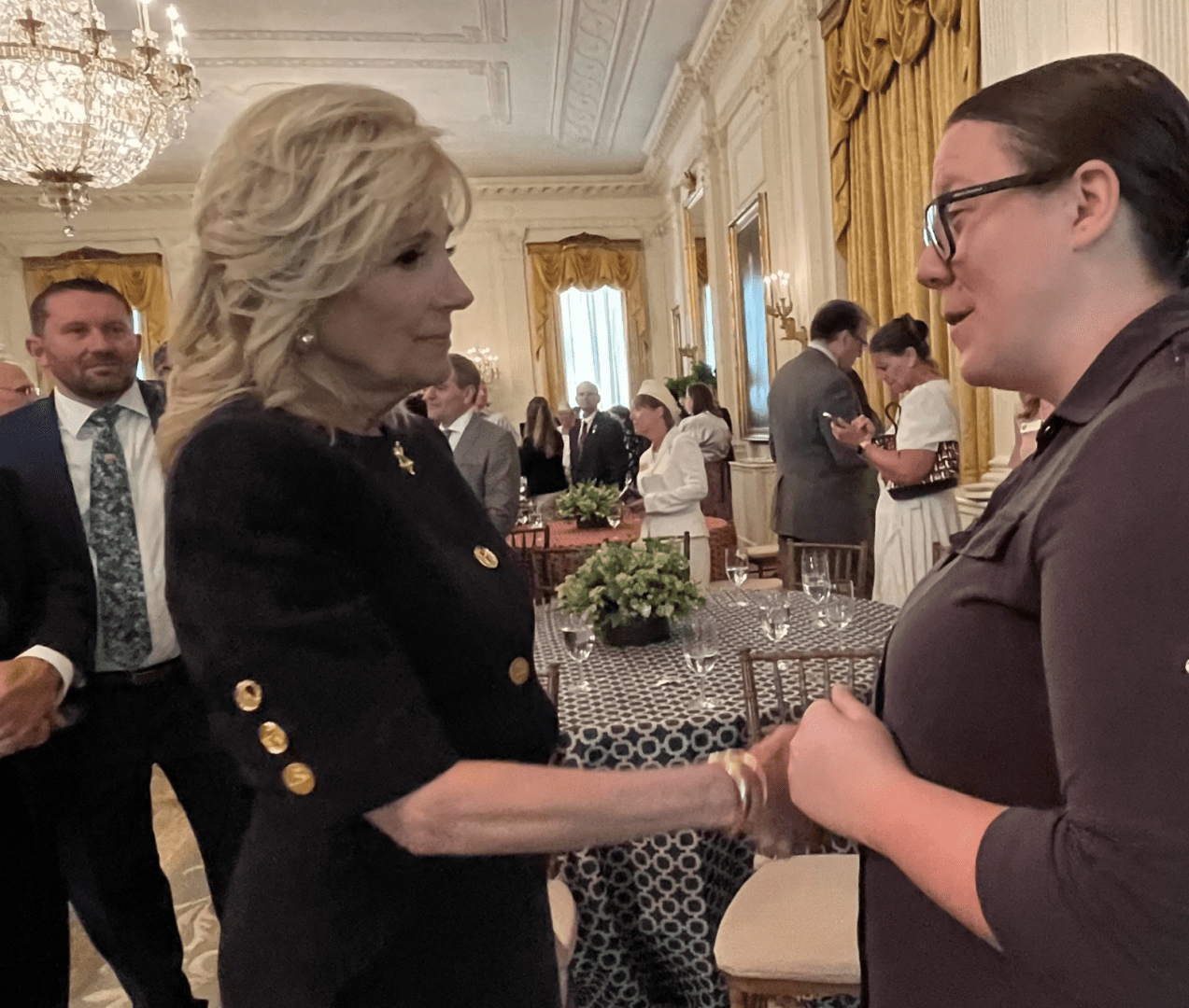 A woman is shaking hands with another woman in a room.
