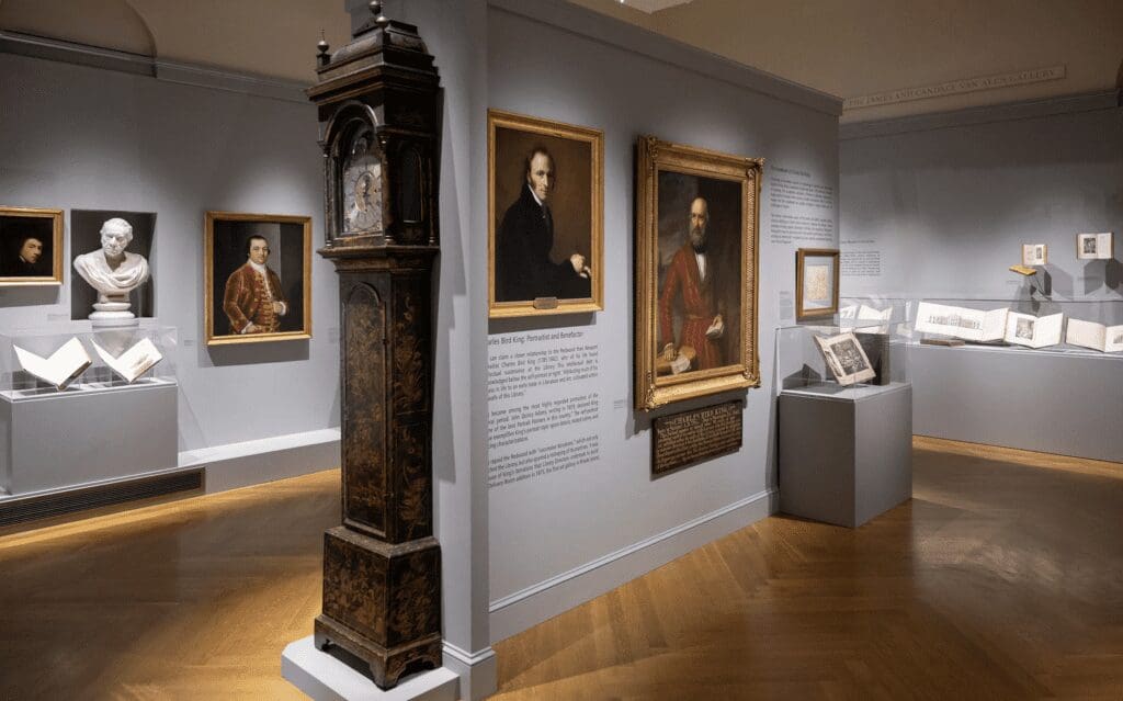 A room with paintings and a clock on display.