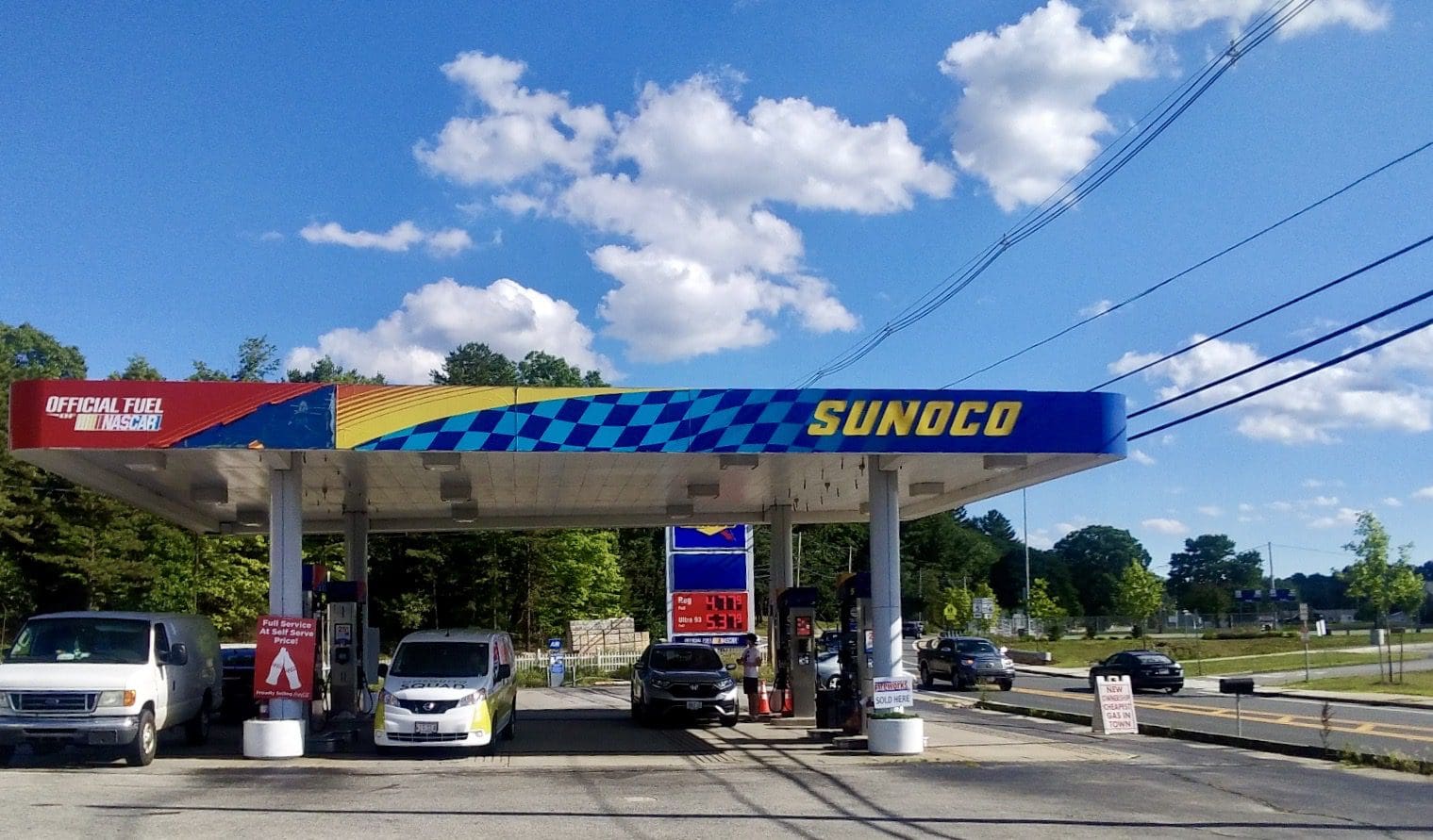 A gas station with cars parked in front of it.