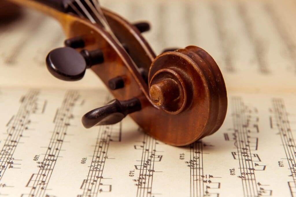 A violin rests on top of a sheet of music.