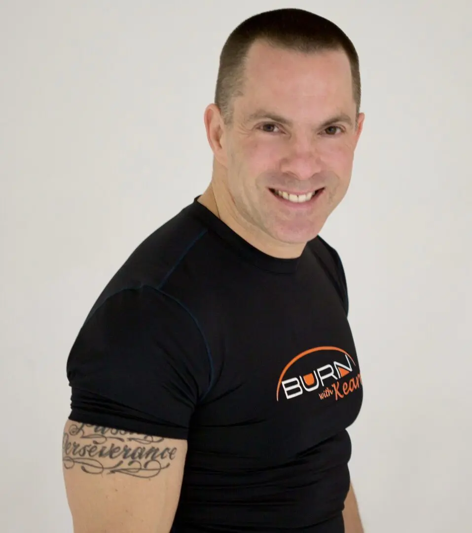 A man in a black t - shirt smiling.