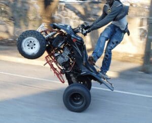 A man riding an atv on a street.