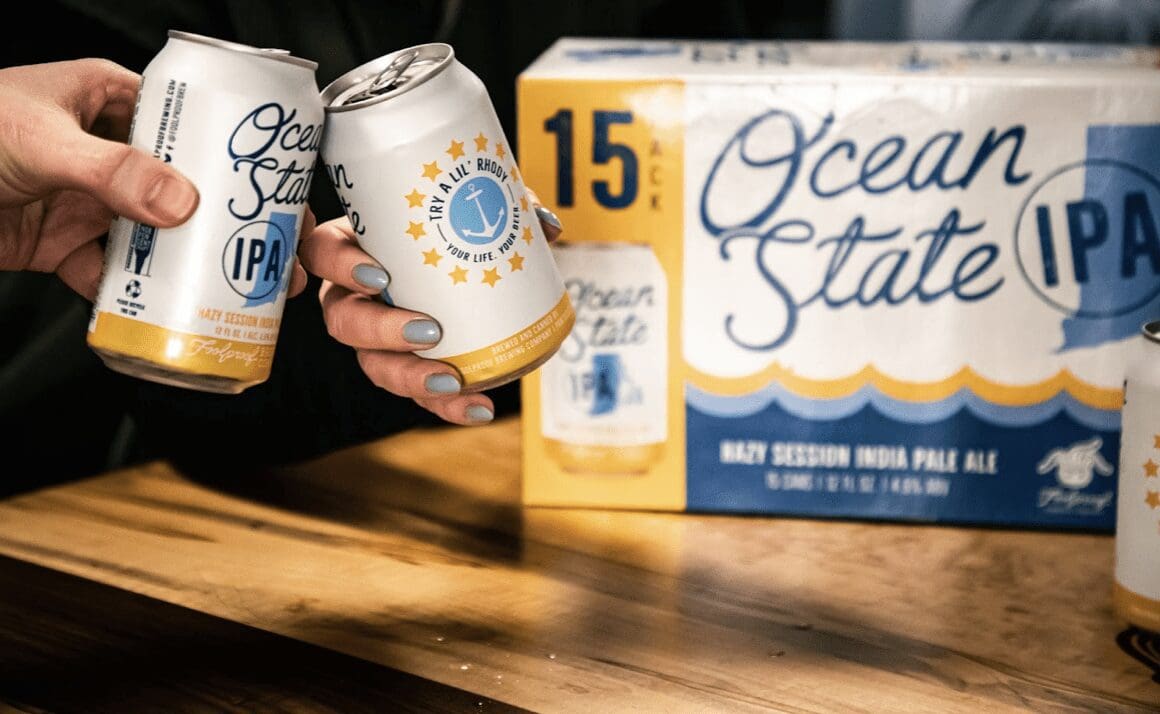 Two people are holding cans of ocean state ipa.
