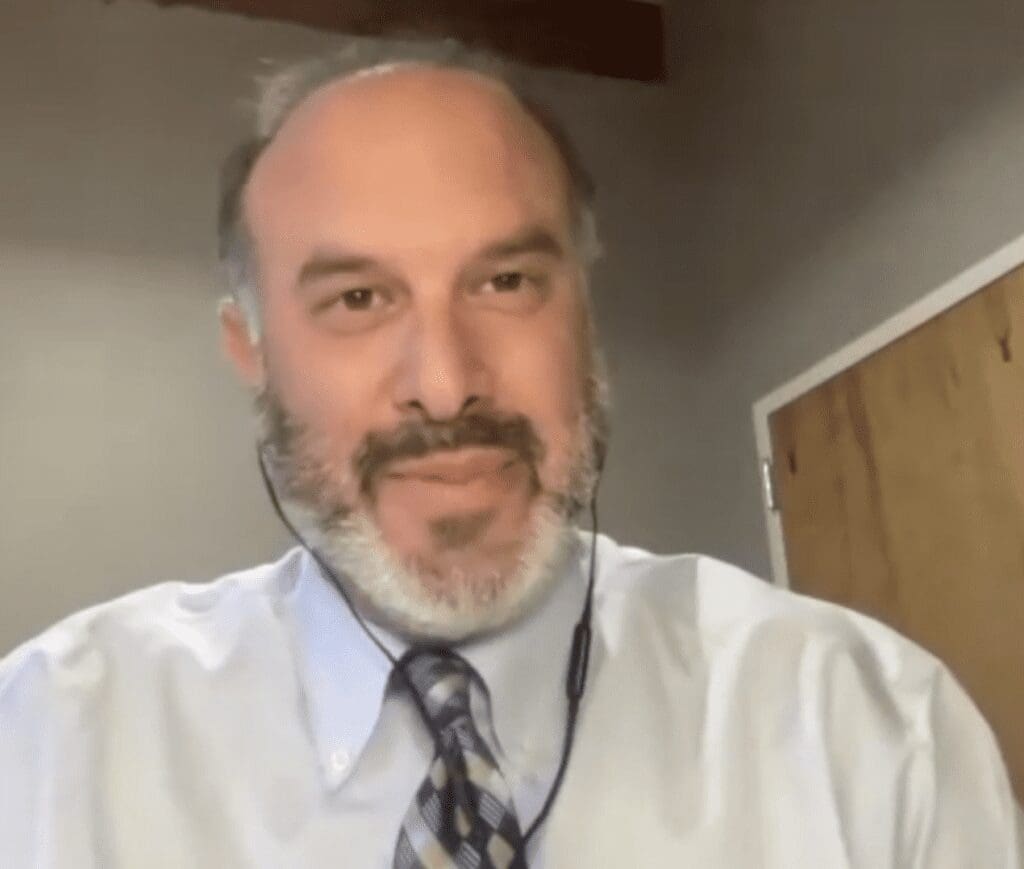 A man with a beard wearing a shirt and tie.