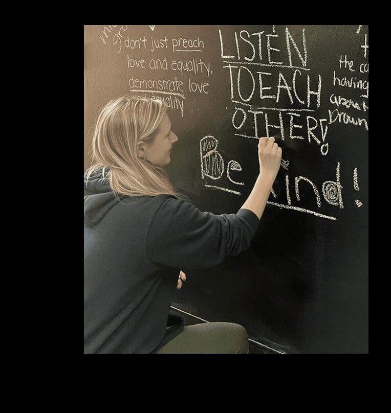 A woman writing on a blackboard.