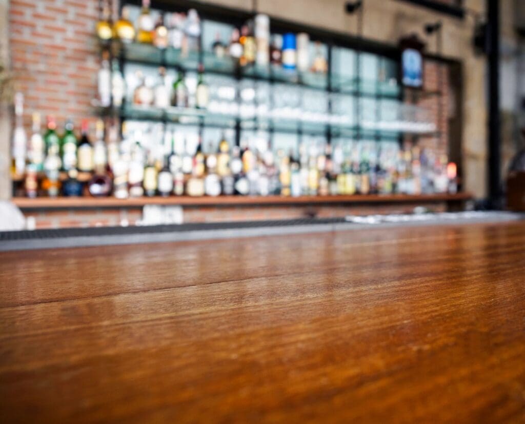 A wooden bar with bottles on it in a restaurant.