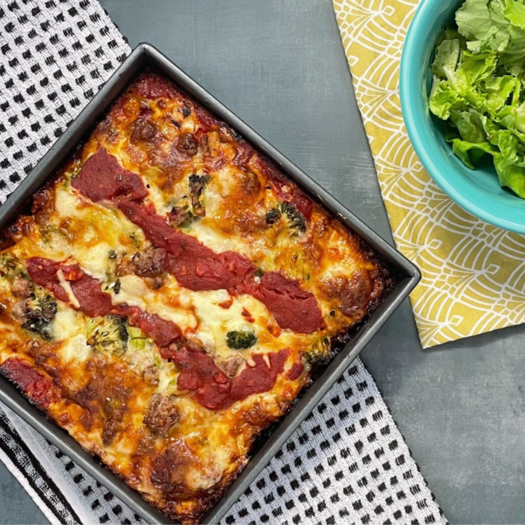 A lasagna with broccoli and meat on a plate.