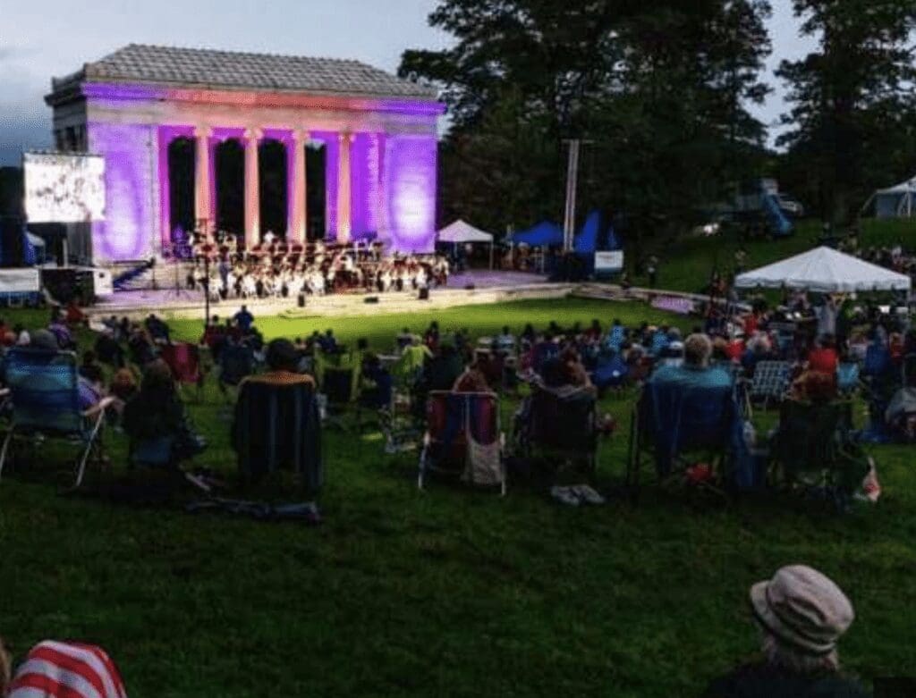 A group of people sitting on lawn chairs at a concert.