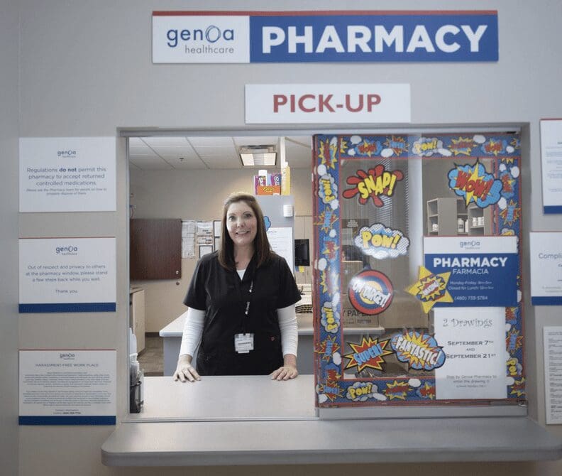 A woman standing in front of a pharmacy counter.