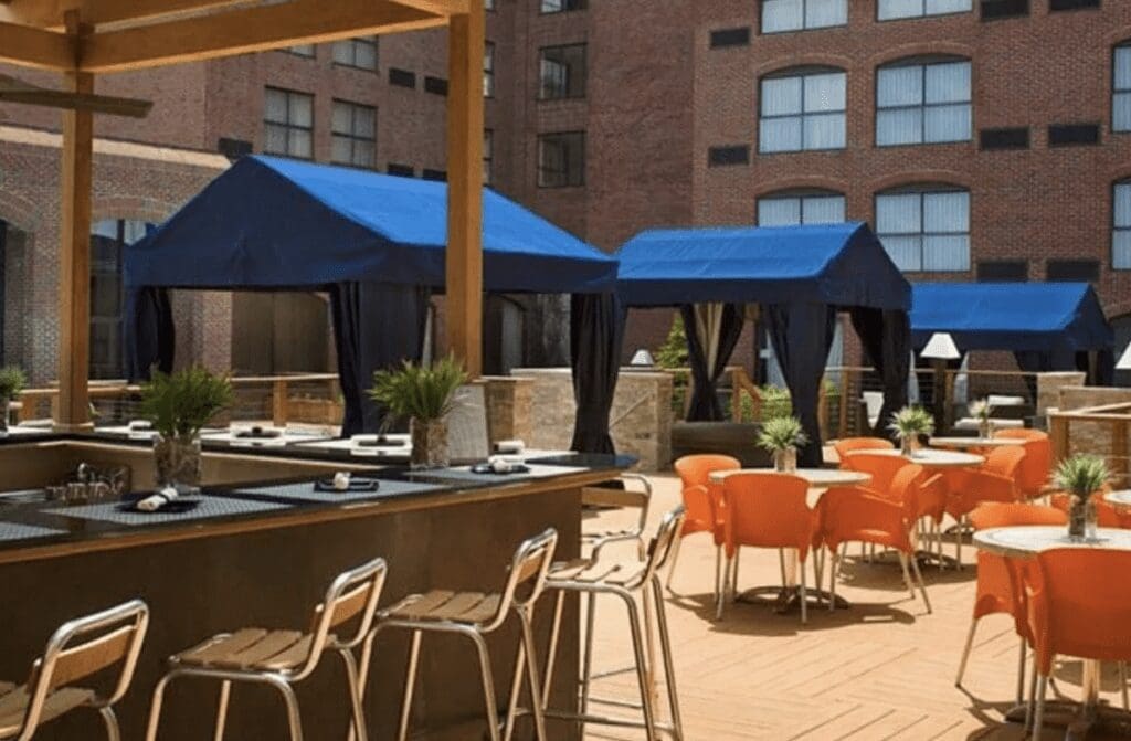 An outdoor patio with orange chairs and umbrellas.
