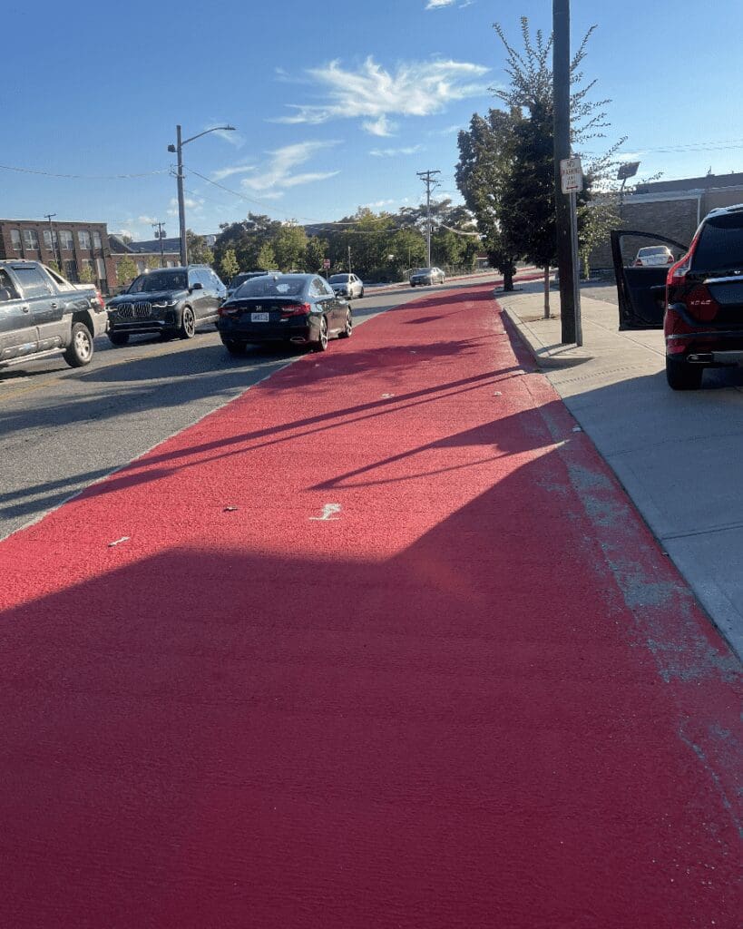 A red painted bike lane on a city street.