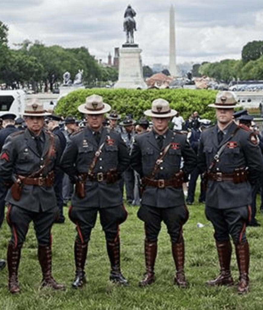 A group of uniformed police officers standing in front of a monument.