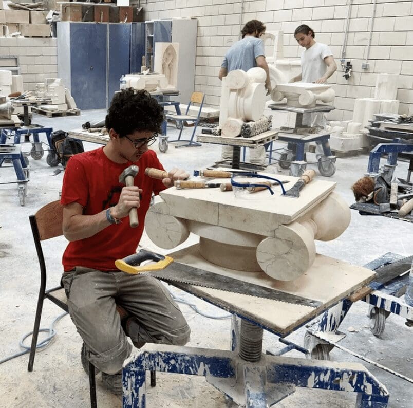A group of people working on a sculpture in a workshop.