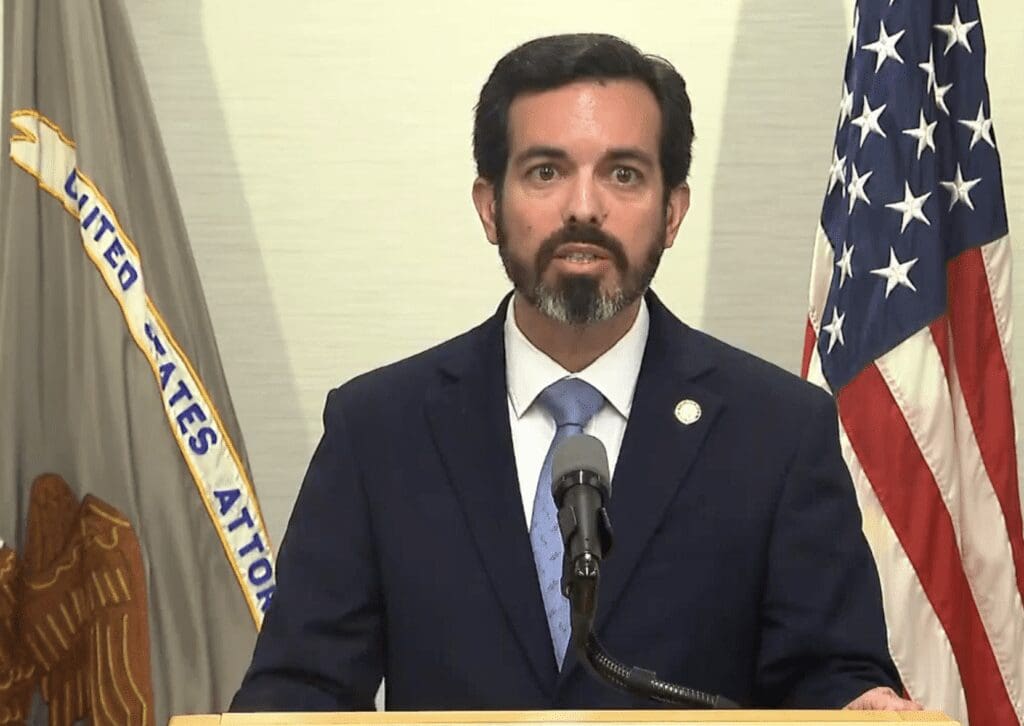 A man in a suit and tie standing at a podium.