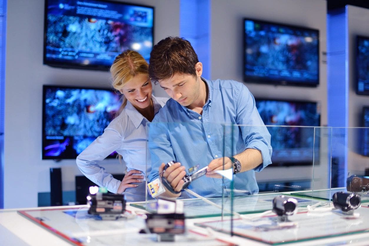 A man and woman looking at electronics in a store.