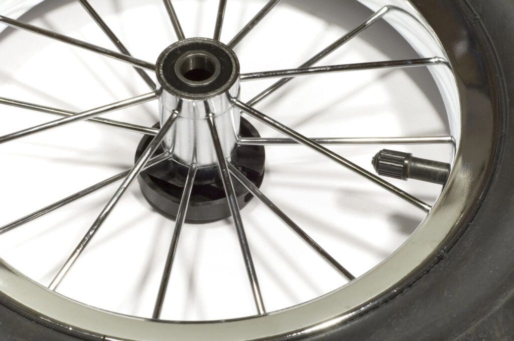 A close up of a bicycle wheel with a spoke.