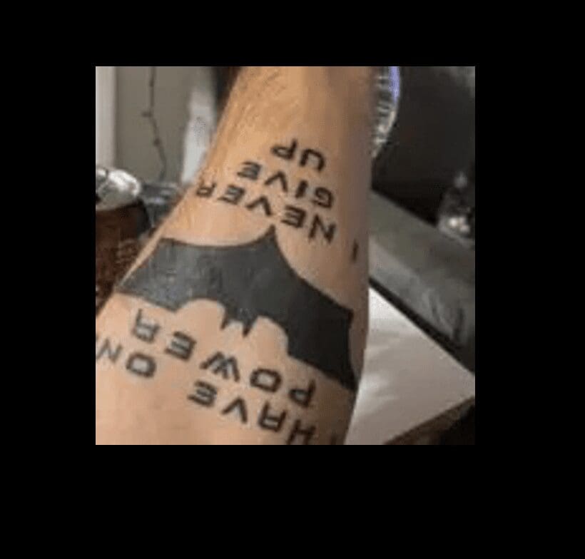 A batman tattoo on a man's arm.