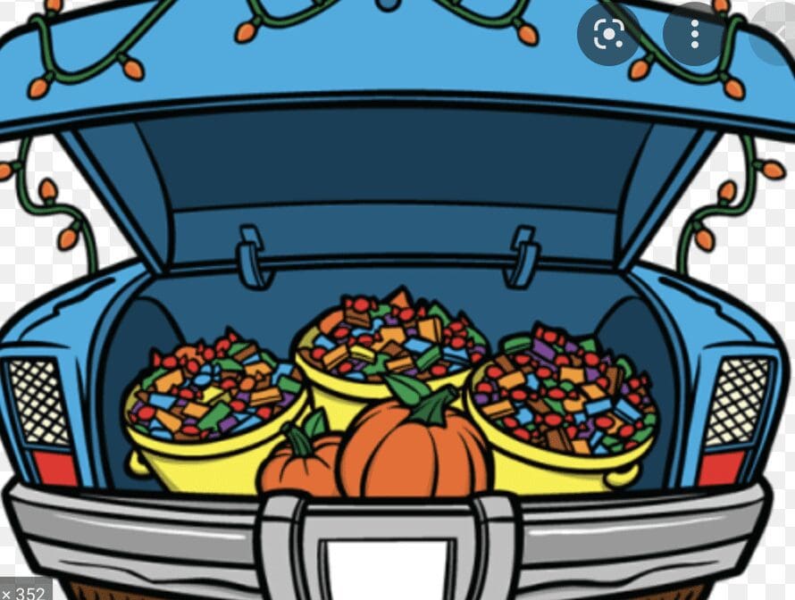 A blue truck with pumpkins and candy in the back.