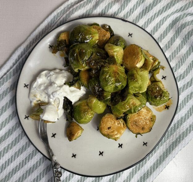 Brussels sprouts with sour cream on a plate.