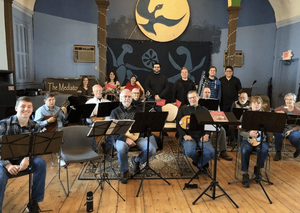 A group of people posing for a picture in a music room.