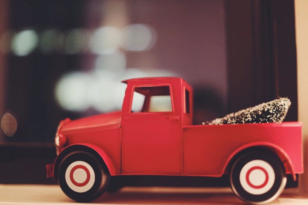 A red toy truck sits on a window sill.